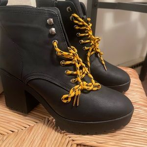Black combat boots with yellow laces